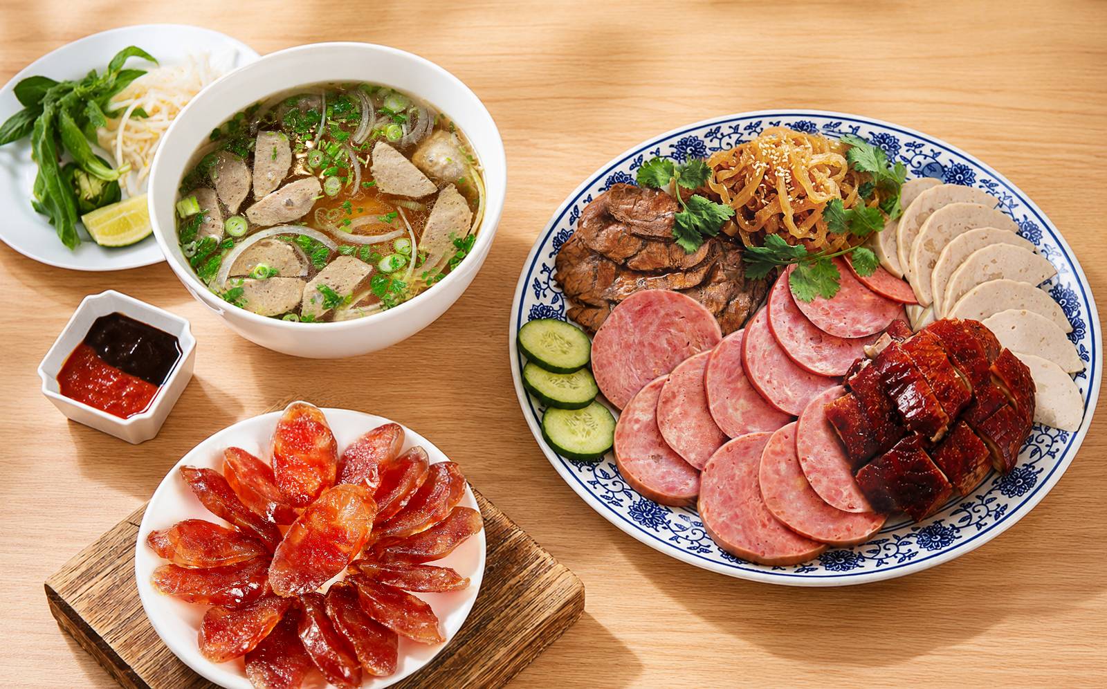 Phở with beef meatballs, sliced lap cheong Chinese sausage and a Vietnamese cold cut platter with chả lụa pork roll